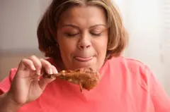 Femme mangeant du poulet