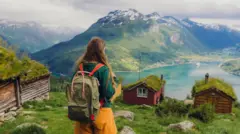 Uma mulher contempla a paisagem rural norueguesa no verão