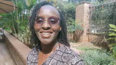 Gladys Nyachieo sorrindo em um jardim