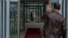 راهرویی در گذرگاه، زنی در حال عبور از گذرگاه، مردی برای او دست تکان می‌دهد