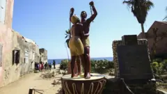 Estátua de homem e mulher em correntes na ilha de Goree, no Senegal. O local é conhecido como a 'Ilha da Vergonha', por ter sido um grande entreposto do comércio transatlântico de pessoas escravizadas, entre os séculos 15 e 19.
