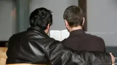 Una pareja de hombres abrazados leyendo la biblia
