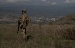 Un soldat azerbaïdjanais se tient devant un avant-poste repris surplombant la ville de Khankendi