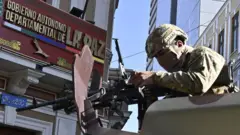 Soldado apunta con un arma desde un tanque.