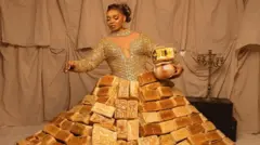 Mercy Atang wọ aṣọ agbekọ oniburẹdi, o si gbe ikoko lọwọ
