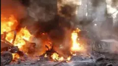 Iná ń jó sókè fíofío pẹlu èéfín ńlá níbi tí àdó olóró tí bù nínú Mọsalasi, ọ̀pọ̀ èèyàn dúró, wọn ń wò rán. 