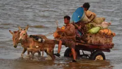 बिपरजोय समुद्री आँधीको जोखिमबाट बच्न ठाउँ सरिरहेका मानिस