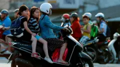 Học sinh tiểu học được cha mẹ chở đến trường 