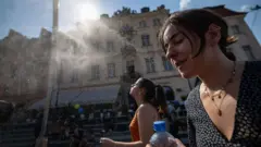 Kobiety chłodzą się pod strumieniem wody.