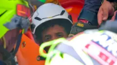 Se ve la cara de un niño, rodeado de equipamiento de rescate