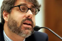 El abogado y activista Daniel Kovalik, con gafas y barba, delante de un micrófono