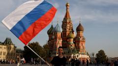 Jovem agita bandeira russa na frente da praça Vermelha,brabet iphoneMoscou