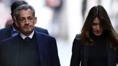 Sarkozy walks next to his wife Carla Bruni-Sarkozy