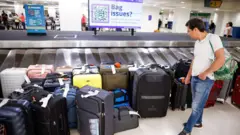 Un hombre junto a una gran cantidad de maletas en un aeropuerto.