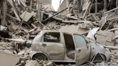 Un coche destruido en Teherán tras ataques aéreos este lunes.