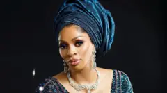 Sade Okoya aolowoiyebiye kan, o we gele pẹlu ẹgba ọrun.