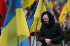 Uma mulher lamenta entre túmulos de militares ucranianos no cemitério de Lychakiv