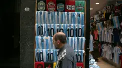 un hombre camina frente a una tienda de ropa en argentina. 