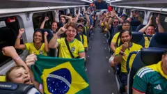 Torcedores brasileiros lotam vagão de trem saindo da Penn Station, em Nova York, para assistir ao jogo Brasil 1x1 Marrocos, no dia 13 de junho de 2026