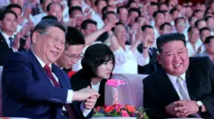 Chinese President Xi Jinping sits next to North Korean leader Kim Jong Un as he attends a performance at the Pyongyang Indoor Stadium, during his state visit, in Pyongyang, North Korea, June 8, 2026, in this picture released by North Korea's official Korean Central News Agency.
