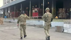 Двоє поліцейський ідуть повз сортувальний центр Нової Пошти