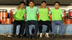 Quatro gandulas posam para a foto, com coletes verdes. No centro, Gerson Portales e Óscar Menéndez. Foto tirada no Estádio Óscar Alberto Quiteño em 11 de outubro de 2025, quando o time local do FAS enfrentou o Municipal Limeño, em Santa Ana, El Salvador.