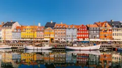 Casas coloridas e barcos em dia de sol em Copenhague, na Dinamarca