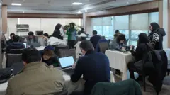 بازرگانان ایرانی پشت میز در اتاق بازرگانی تهران مشغول کار با نیم ساعت دسترسی به اینترنت