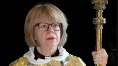 Biṣọọbu Agba Canterbury tuntun, Sarah Mullally, wọ aṣọ olomi ọsan ati funfun, o si mu ọpa lọwọ