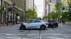 Vehículo eléctrico autónomo Waymo en Market Street, entre torres de oficinas del centro de San Francisco, California, el 13 de mayo de 2025.