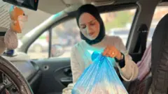 شابة تحمل كيساً من الخبز