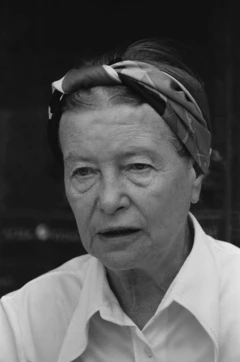Simone de Beauvoir com uma camisa branca e um lenço amarrado na cabeça