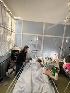 Astorga junto a la cama de una mujer trans que está hospitalizada.