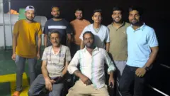 Los tripulantes del Stratos, con dos de ellos sentados en la parte delantera y los seis restantes de pie detrás, sonríen para la fotografía tras el reflotamiento de su barco.