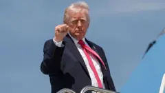 الرئيس الأمريكي دونالد ترامب على سلم طائرة رافعا قبضة يديه اليمنى