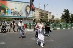 زنی بی حجاب در برابر دیوارنگاری خمینی در تهران