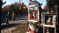 رجال يسيرون في مقبرة شهداء في 8 ديسمبر/كانون الأول 1997 في طهران، إيران. بعد تخفيف القيود المفروضة على الصحافة والتعبير الثقافي خلال ثمانينيات القرن الماضي أثناء توليه منصب وزير الثقافة، يعتزم الرئيس المنتخب حديثًا محمد خاتمي تخفيف حدة النزعة المحافظة السائدة المرتبطة بالثورة الإسلامية عام 1979، وإعادة فتح قنوات التواصل مع الغرب.