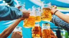 Mãos erguendo copos grandes de cerveja em um brinde