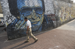 Un hombre pasa junto a un mural de Héctor Lavoe en Lima.