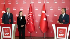 Bir erkek ve bir kadın solda. İkinci bir erkek sağda. Hepsi CHP yazan kürsülerin arkasında duruyor. Arkada CHP ve Türkiye bayrağı var. 
