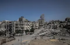 Escombros de prédios em Gaza, com fumaça