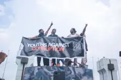 Jovens segurando uma faixa que fiz "juventude contra corrupção"