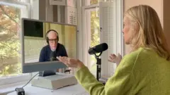 แคตตี เคย์ ผู้สื่อข่าวบีบีซี (ขวา) ขณะสัมภาษณ์ สกอต กัลโลเวย์ ผู้เชี่ยวชาญด้านปัญหาสังคมอเมริกัน