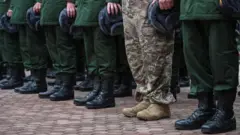 Pernas de homens usando calças e sapatos militares