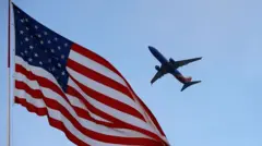 A Southwest Airlines Boeing 737 departs from San Diego International Airport with an American flag in the foreground 