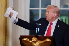 Президент США Дональд Трамп тримає модель Тріумфальної арки зі статуєю Леді Свободи на вершині під час бальної вечері у Східній кімнаті Білого дому у Вашингтоні, жовтень 2025