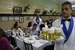 Garçom com chopes em restaurante