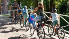 Una pareja con sus tres niños paseando en bicicleta en Holanda