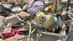 Mochilas coloridas de crianças e um brinquedo Minion do desenho 'Meu Malvado Favorito' estavam entre escombros e barras de metal onde uma pré-escola desabou no terremoto.