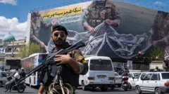 Un soldado iraní y detrás una pancarta sobre el estrecho de Ormuz